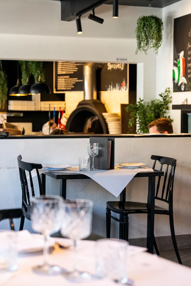 Intimate table set for a festive dinner beside the wood-fired oven at La Botte D'Oro, Leichhardt