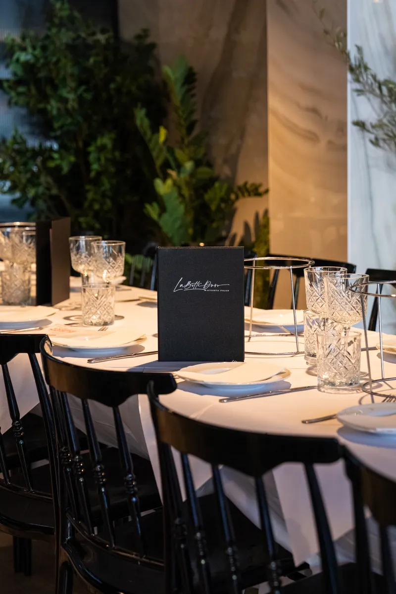 Round table set with a branded menu for an exclusive event at La Botte D'Oro, Leichhardt