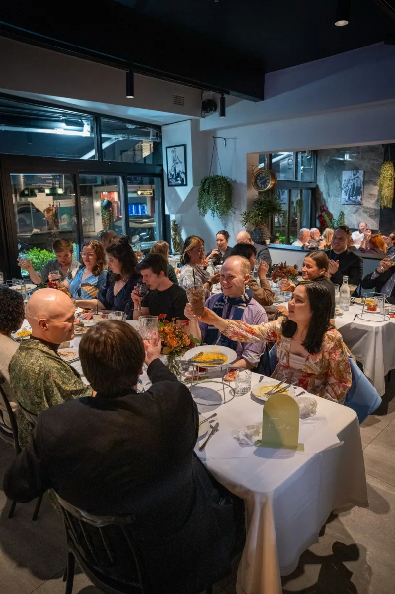 Guests raising a toast around the table at a birthday celebration at La Botte D'Oro, Leichhardt