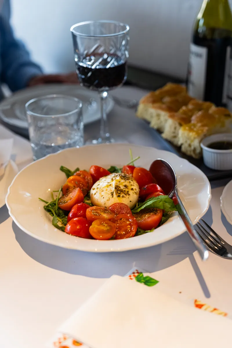 Tomato, bread, olive oil and a glass of red wine on the table at La Botte D'Oro, Leichhardt